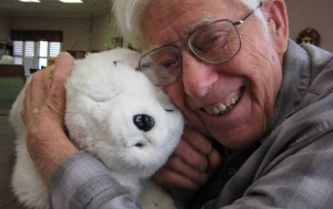 Elderly human Male Hugging Paro to Robot Seal